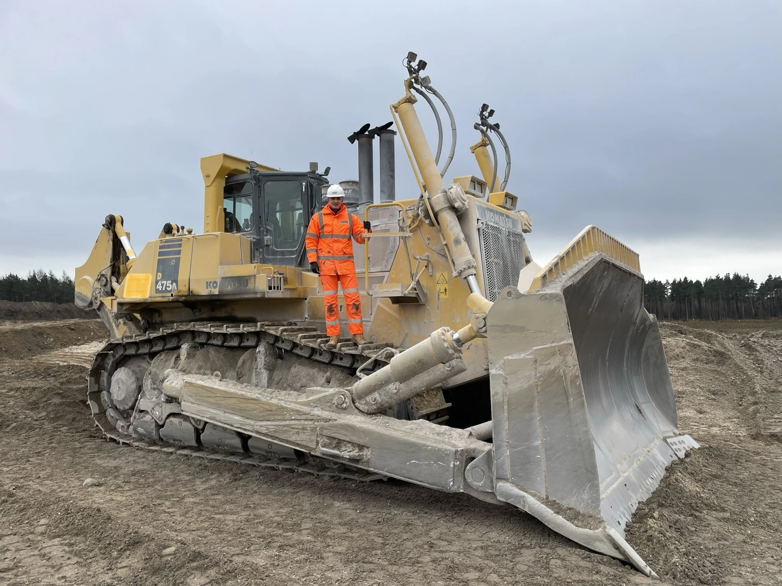 Callum Maund alongside a large Komatsu crawler dozer on site